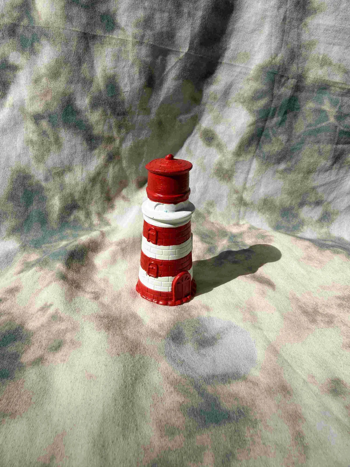 Faro de cerámica pintado a mano en rojo y blanco con detalle de pincel