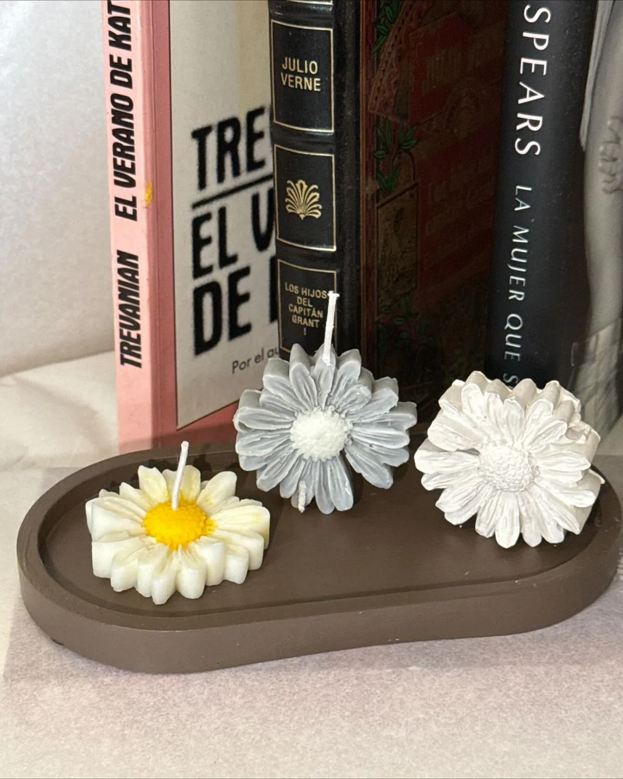 Velas artesanales en forma de margarita con detalle de textura en bandeja