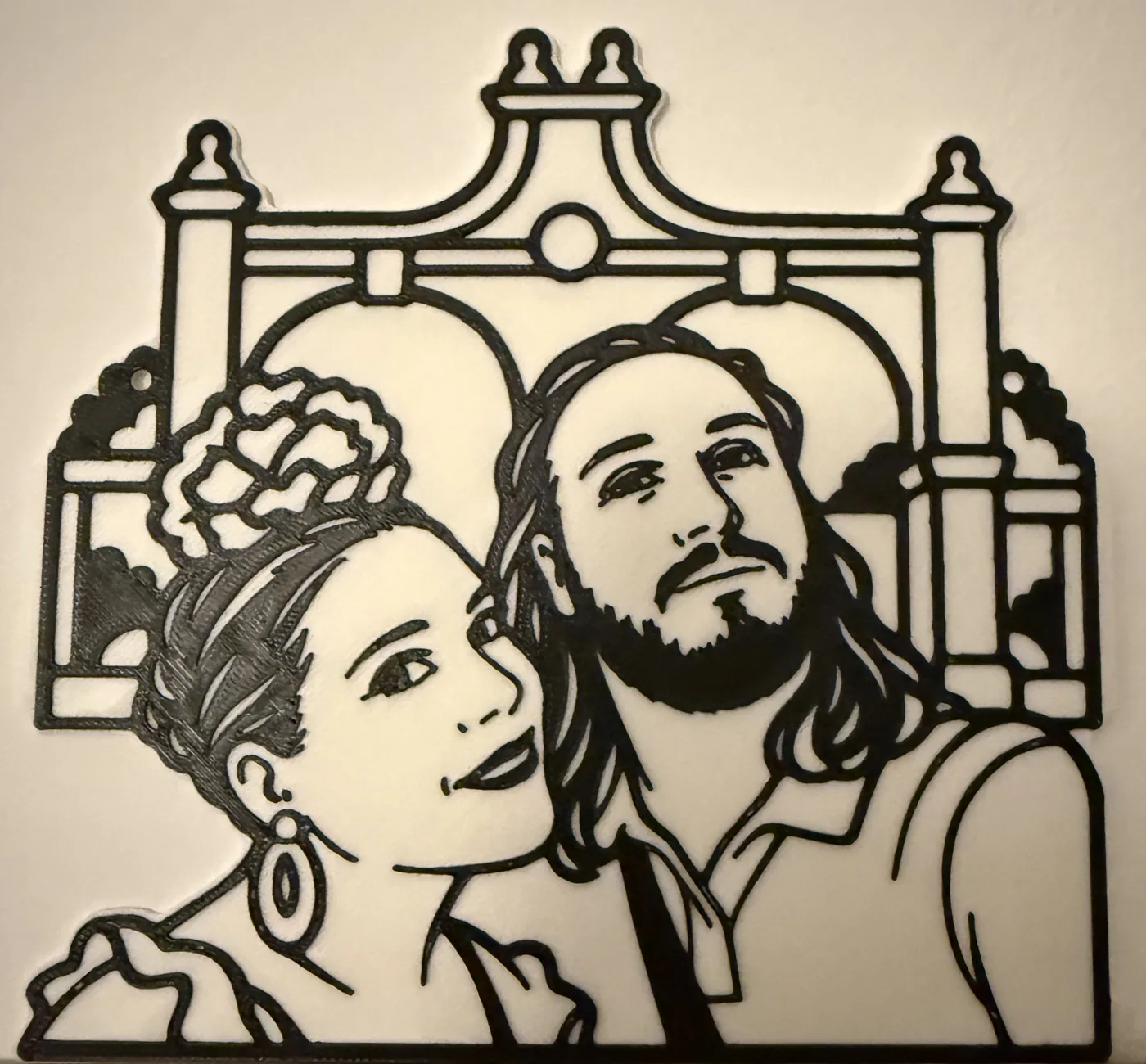 Retrato personalizado impreso en 3D en dos colores, negro sobre blanco, de una pareja frente a un monumento